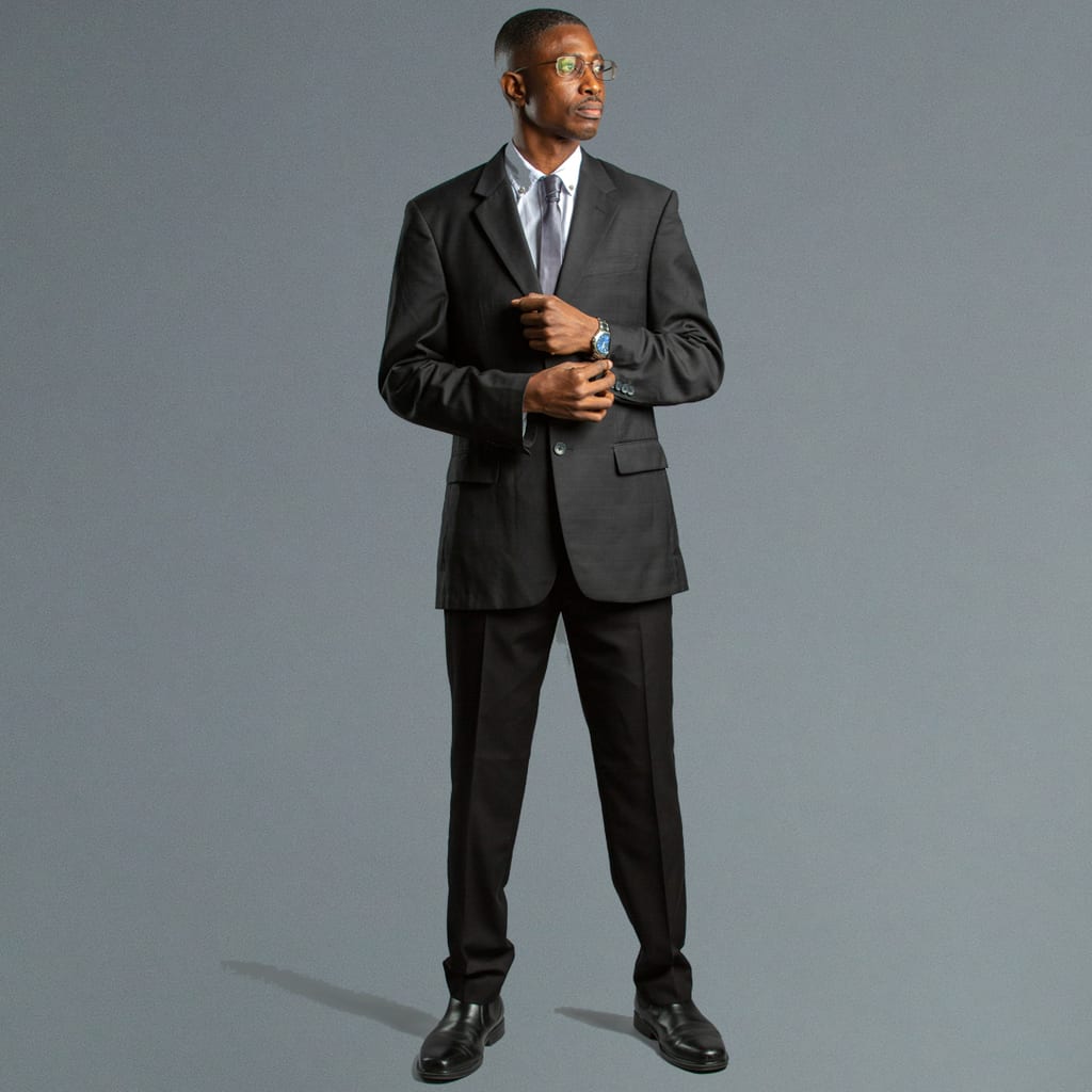 Full-length studio portrait of a man in a tailored charcoal two-piece suit